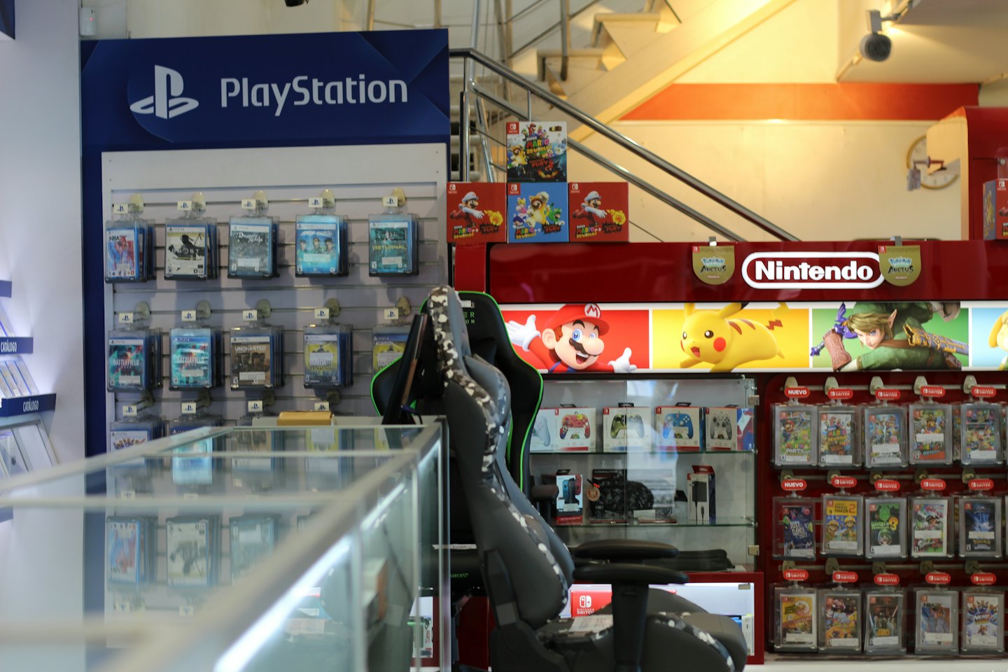 Negozio di videogiochi con scaffali pieni di giochi e una sedia da gaming.