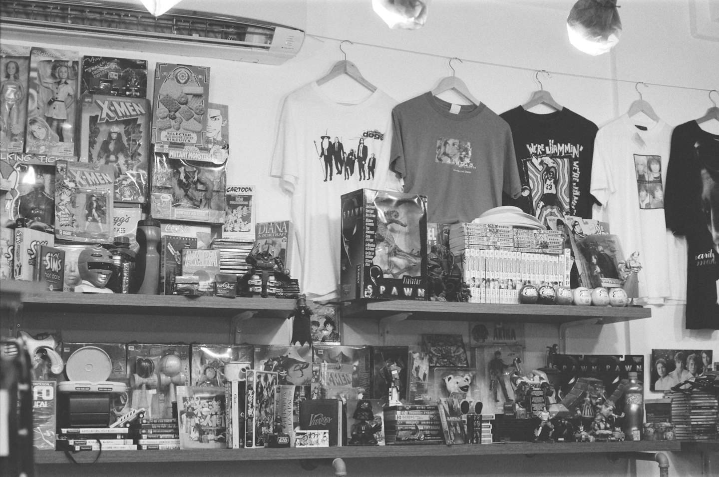 Scaffali pieni di merchandising della cultura pop e magliette appese.