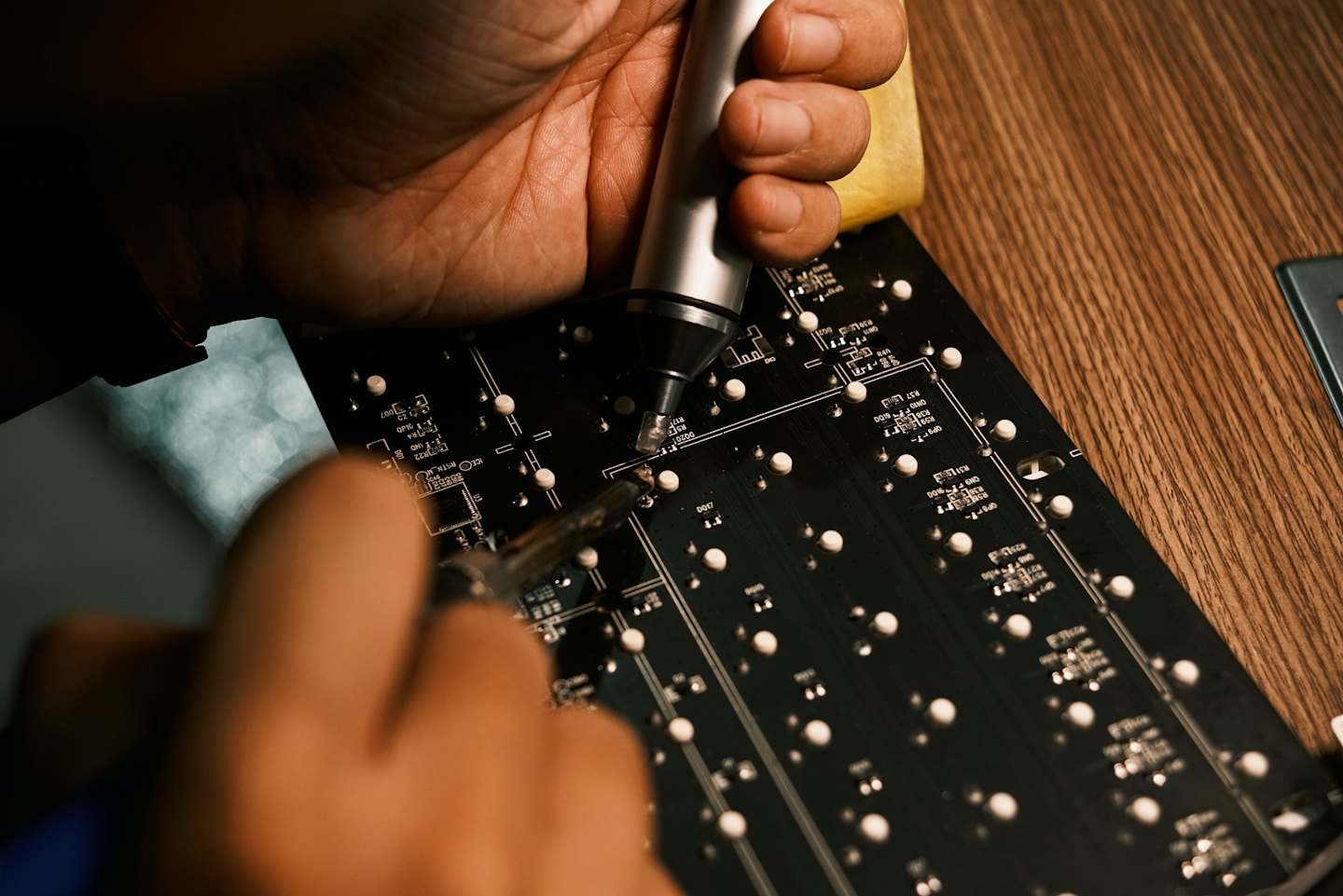 Un tecnico usa strumenti di saldatura per riparare un circuito stampato.