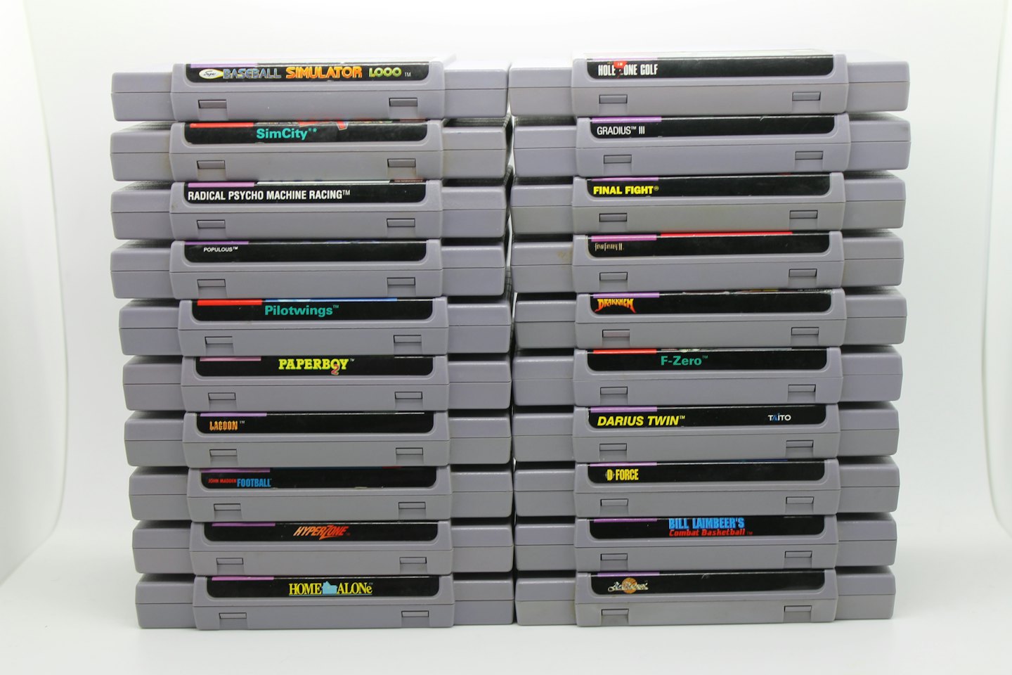 Due pile verticali di classiche cartucce per videogiochi SNES.